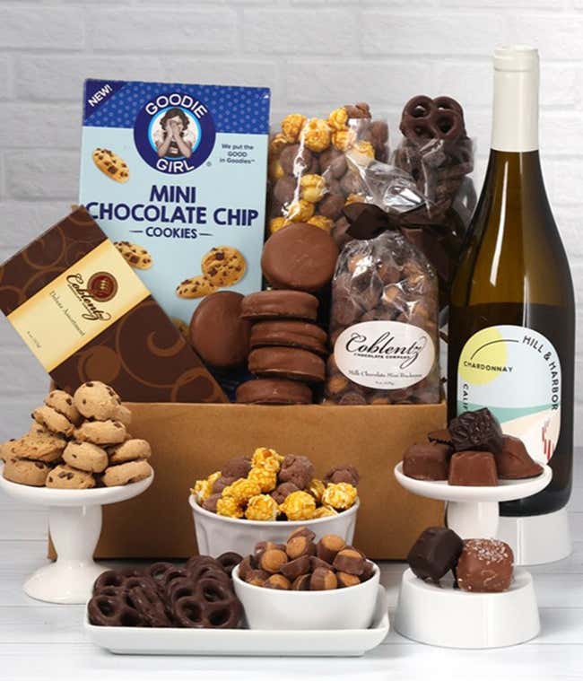 A gift set featuring a bottle of Hill &amp; Harbor White Wine alongside chocolate-covered pretzels, mini cookies, caramel popcorn, chocolate-covered almonds, and 6 chocolate-covered Oreos. Includes a box of assorted chocolates for a luxurious touch.