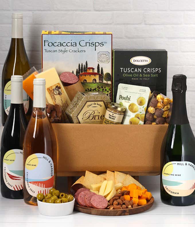 A wine and cheese gift set featuring 4 bottles of Hill & Harbor - Sparkling wine, Rosé wine, Chardonnay, and Pinot Noir. Includes a variety of cheeses, crackers, olives, smoked almonds, summer sausage, and condiments.